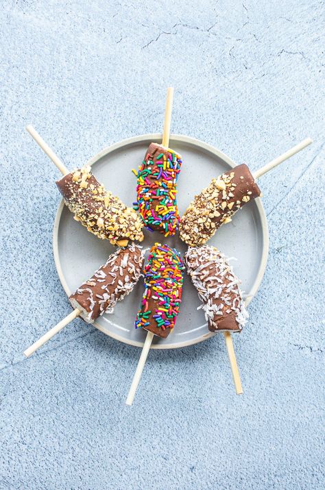 This easy and fun recipe for chocolate-dipped frozen banana pops is a perfect cold treat to enjoy on hot summer days. Top these frozen bananas with a homemade Nutella magic shell, chopped nuts, coconut, or sprinkles! #frozenbanana #frozenbananapops #chocolatecoveredbananas #homemademagicshell Nutella Dip, Chocolate Dip Recipe, Homemade Magic Shell, Frozen Banana Pops, Chocolate Dipped Bananas, Choco Banana, Banana Pops, Magic Shell, Chocolate Covered Bananas