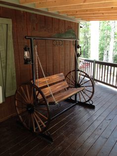 Porch swing with wagon wheel sides and working kerosene lanterns. Wooden Swing, Rustic Porch, Primitive Homes, Porch Furniture, Swing Chair, House With Porch, Wagon Wheel, Western Decor, Repurposed Furniture