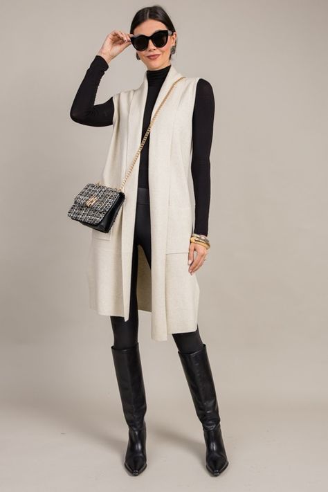 This cardigan features a sleeveless design that looks so chic when layered over simple long sleeve tops and turtlenecks. The drapey fit is characterized by an open front, a shawl collar, and a long length. Patch pockets complete the look.    Open front   Patch pockets  Side slits  Fabric content: Self- 40% viscose, 32% chinlon, 28% polyester  Sweater knit offers stretch    Fit is true to size. Models are wearing size... Long Vest Office Outfit, Dressy Business Casual Outfits For Women, Long Wool Vest Outfit, Oatmeal Cardigan Outfit, Long Sleeveless Cardigan Outfit, Long Sweater Vest Outfit, Long Vest Outfit Fall, Sweater Vest Outfit Fall, Cardigan And Dress Outfit