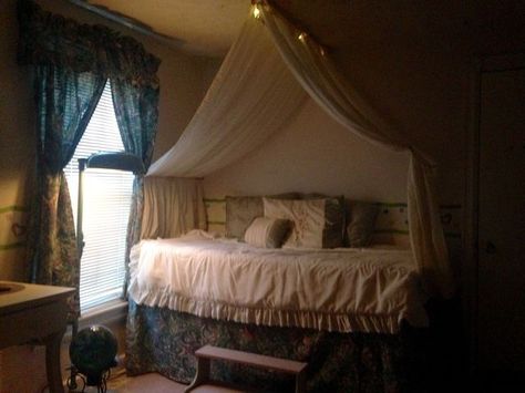 I decided to turn a twin bed into a raised daybed so I could store boxes underneath.  One thing led to another and I created my own "diy" bed canopy.  I love to repurpose  things so this cost me no money .... only some rummaging in my attic.  The canopy uses two wooden dowels as "curtain rods".  I put 2 sheer curtain panels on each.  I then put 4 screw hooks in the ceiling to hold the dowels.  The rest is a thumbtack here and there. Easy! Twin Bed Canopy Diy, Diy Canopy Twin Bed, Diy Bed Drape, Canopy Bed Against Wall, Canopy Over Daybed, Diy Canopy Curtains, Couch Canopy, Diy Bed Canopy Easy, Curtains Over Bed