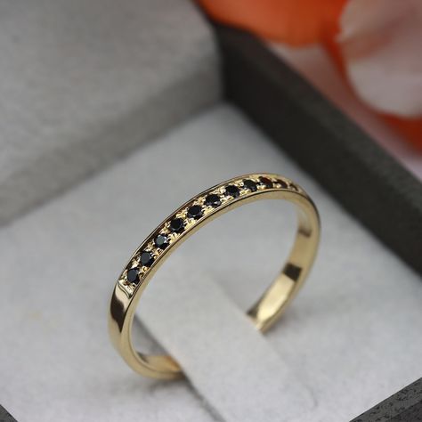 This exquisite half eternity ring features 11 stunning black onyx gemstones set in a beautifully crafted band. The timeless design of this ring showcases the deep, lustrous hue of each gemstone, creating a striking contrast against the high-polish finish of the metal. The black onyx stones, which are believed to provide protection and strength to the wearer, are elegantly arranged in a row along the top half of the ring, creating an alluring and sophisticated look. Crafted from high-quality mate Onyx And Gold Jewelry, Black And Gold Wedding Ring For Women, Classic Black 14k Gold Stackable Rings, Black Onyx Stackable Jewelry, Fine Jewelry Black Onyx Diamond Ring, Black Onyx Stackable Ring, Fine Jewelry Onyx With Black Diamonds, Black Onyx Stone, Silver Stacking Rings