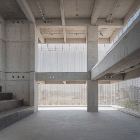 The concrete slab superstructure has been left raw, with glimpses of the slim pillars and beams through the metal. Light filters through to the interiors, unobstructed by concrete outer walls. Clean Concrete, Metal Facade, High Building, Light Filters, Concrete Pool, Spanish Architecture, Exposed Concrete, Concrete Structure, Concrete Slab