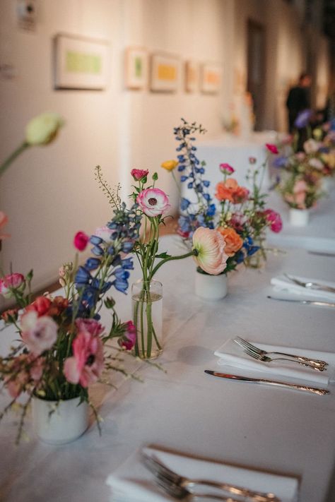 Colorful Bud Vase Centerpiece, Bright Fall Wedding Flowers, Round Table Bud Vases, Wildflower Centerpiece Wedding, Wildflower Bud Vases, Colorful Wedding Centerpieces, Bud Vases Wedding, Creative Floral Design, Bud Vase Centerpiece