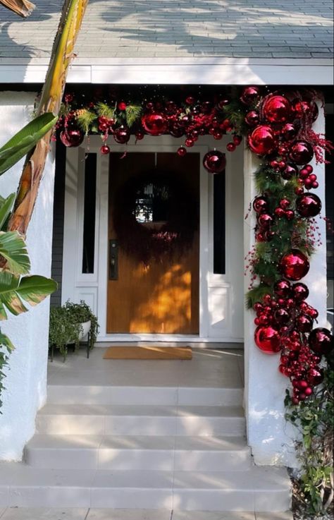 Christmas Bauble Door Arch, Upscale Outdoor Christmas Decor, Outdoor Christmas Garland With Ornaments, Outdoor Christmas Decorations Pillars, Christmas Bauble Arch, Bauble Garland Front Door, Garland On House Exterior, Christmas Lights Front Door, Media Wall Christmas Decor