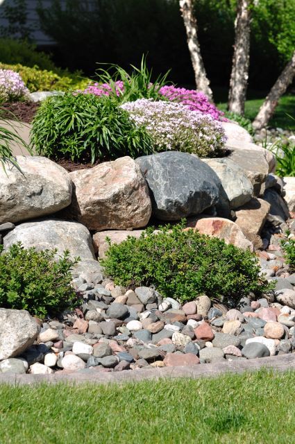 Here’s a great concept when searching for retaining wall ideas for a slope. The natural rocks may seem like they were just there by chance, but the rocks actually serve as a pretty great wall. The larger stones compared to the smaller rocks at the bottom make the whole scene look rugged and natural. This is a perfect décor concept for a minimalist or someone who doesn’t like too many frills outside. Retaining Wall Ideas, Rock Retaining Wall, Garden Retaining Wall, Sloped Backyard, Stone Retaining Wall, Landscaping With Boulders, Landscaping Retaining Walls, Hillside Landscaping, Sloped Garden