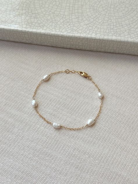 Please review the bracelet sizing guide below for the perfect fit! This dainty natural Pearl bracelet looks perfect for special occasions or can elevate any casual outfit. Each Pearl is hand wrapped skin friendly 14K Gold Filled or 925 Sterling Silver. Every bracelet comes with a small extender for adjustable sizing. You will feel sophisticated and chic when you put it on! Pair it with the Gianna Pearl Earrings or Isla Pearl bracelet for a lovely matching set! * 6-7mm freshwater Pearls * Pearl s Pearl And Gold Bracelet, Pearl Bracelet Designs, Bridal Pearl Bracelet, Pearl Gold Bracelet, Wedding Jewelry Bride, Dainty Pearl Bracelet, Jewelry Bride, Bridal Bracelet Pearl, Pearl Bracelet Gold