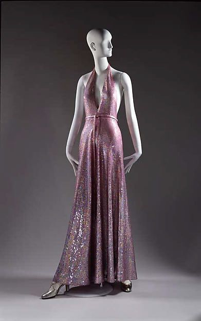 Evening dress, Halston, 1974: This dress incorporates the popular style of a halter neck line and glamorous, flashy sequined fabric into a sleek, fluid design. Halston Vintage, Fashion History Timeline, Halston Dress, Fashion 1970s, Fashion Queen, 20th Century Fashion, Vintage Gowns, 1970s Fashion, Moda Vintage