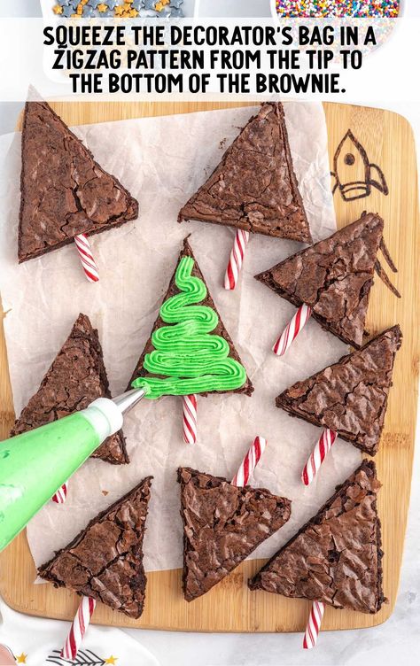 using ziploc bag frost the brownie on a wooden board Green Buttercream Frosting, Tree Brownies, Green Buttercream, Christmas Tree Brownies, Christmas Brownies, Store Bought Frosting, Mini Candy Canes, Homemade Brownies, Brownies Recipe