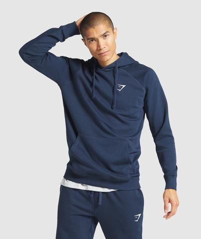 REST DAY THE CREST WAY   ⁃ Slim fit  ⁃ Three-piece hood with adjustable drawcord  ⁃ Pouch pocket to front  ⁃ Ribbed hem and cuffs  ⁃ Embroidered Gymshark logo to chest  ⁃ 80% Cotton, 20% Polyester  ⁃ Model is 6'1" and wears a size M  ⁃ Label Colour: Navy  The Men’s Crest Hoodie is an essential layer for the workout commute or to complete any gym style. Boasting a warm cotton-blend fabric, an incredibly soft interior and a minimalist design, you can’t go wrong with Crest. Stylish Gym Outfits, Mens Photoshoot Poses, Gym Outfit Men, Rest Day, Gym Clothing, Fashion Suits For Men, Workout Attire, Gym Style, Outerwear Outfit