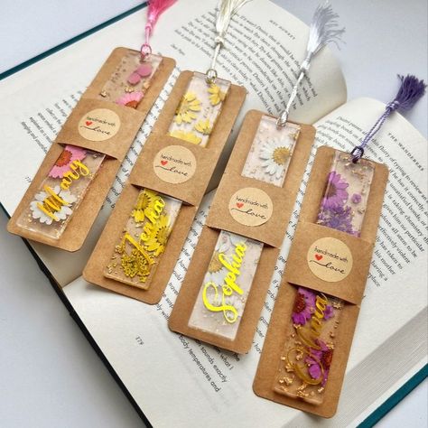 Pressed dried flowers in resin bookmarks, featuring colors like pink, purple, and yellow flowers. The bookmarks are presented in kraft paper sleeves and displayed on top of a book Pressed Flower Bookmark, Heart Bookmark, Flower Acrylic, Unique Bookmark, Personalized Bookmarks, Flower Bookmark, Etsy Personalized Gifts, Pressed Flower, Timeless Treasures