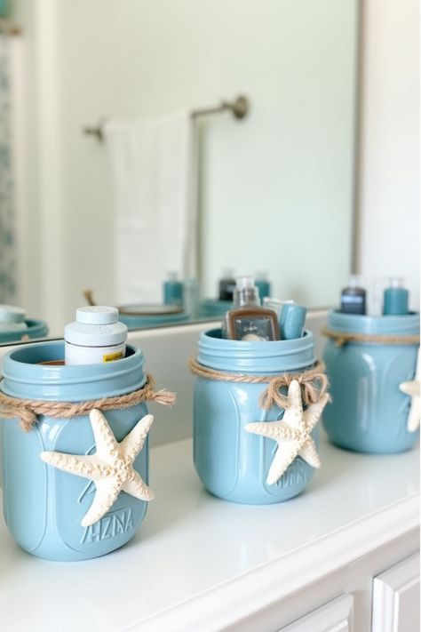 Painted mason jar bathroom organizers in coastal colors with starfish decorations Beach Bathroom Ideas Coastal Style, Diy Driftwood Decor, Beach Bathroom Ideas, Mason Jar Bathroom Organizer, Ocean Themed Bathroom, Diy Driftwood, Bathroom Organizers, Driftwood Mirror, Mason Jar Bathroom