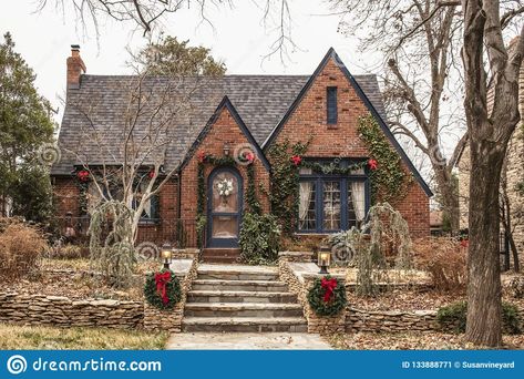 Photo about Cute brick cottage with red bows and greenery - decorated for Christmas in bleak wintertime. Image of exterior, garland, decorations - 133888771 Iron Front Doors, Wrought Iron Front Door, Brick Cottage, Tudor Cottage, Tudor Style Homes, Cottage Exterior, Brick Exterior House, Tudor House, Dream Cottage