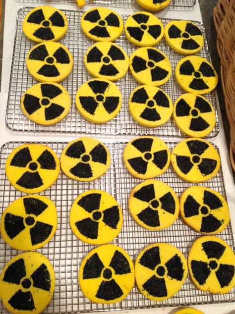 I made some yummy radioactive cream cheese cut out cookies for my Hubbies Godzilla themed birthday. I got an image of the radioactive symbol from the internet and made a stencil from an old plastic lid from a deli container. It is the same kind of plastic lid that is on coffee cans. I kept the lip of the lid up so the sugar wouldn't spill off of the lid. I lightly pressed the plastic stencil into the dough and rubbed the sanded sugar into the cookie dough then baked. Radioactive Theme Party, Radioactive Party Ideas, Kaiju Party Ideas, Godzilla Themed Food, Xenomorph Birthday Party, Radioactive Party, Fallout Wedding, Fallout Theme, Godzilla Party