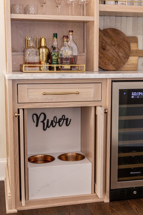 Built into the cabinet, this pet feeding station has sliding doors that retract into the cabinet, but can also be closed when needed. Surrounded with durable quartz. End Of Cabinet Dog Bowls, Kitchen Cabinet Dog Bowls, Dog Feeding Station In Cabinet, Dog Bowl Kitchen Cabinet, Dog Bowl Under Sink, Coffee Bar Dog Feeding Station, Dog Food Cabinet In Kitchen, Dog Cabinet Organization, Dog Food Set Up