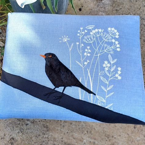 🌿✨ Introducing the Blackbird in Summer footstool! 🌞 I'm pleased to reveal my latest creation - a charming footstool adorned with intricate embroidered cow parsley dancing across a serene blue sky background, with a delightful appliquéd blackbird perched atop a tree branch, singing his little heart out. Inspired by a lovely early summer day like today., when you can't beat the beautiful British countryside, with wildflowers swaying in the breeze and birdsong fills the air. This lovely vint... Embroidered Cow, Cow Parsley, Blue Sky Background, British Countryside, Sky Background, Blackbird, Tree Branch, Summer Day, Black Bird