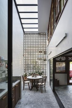 A new semi-outdoor space is created by enclosing the former house’s foyer with a skylight and concrete breeze-block screen. It functions excellently as a wet kitchen, with cooking smells filtering through the screen. Minimalism Living, Home Designs Exterior, Narrow House, Minimal House Design, Tropical House, Patio Interior, Minimal Home, Courtyard House, Small Backyard Patio