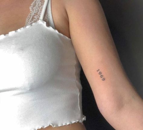 “1969” arm tattoo Size The Day Tattoo, Upper Arm Tattoo Minimalist, 1969 Tattoo Ideas, Lots Of Small Tattoos Arm, Year Arm Tattoo, Birthyear Tattoo On Arm, Tattoo Going Down Arm, Year Tattoo On Arm, Year Tattoo Placements