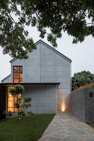 Vernacular barn forms have come to town in this double gable house – an exhibition of precision in concrete and steel. Expertly handled natural light across precast and in-situ concrete creates a warm and bold interior. Intense attention to European-influenced detailing has created a controlled and defined home of very high quality. Clever planning has reduced the large kitchen and scullery areas typical of houses of this type, ensuring an appropriate scale is maintained. Concrete Homes Exterior, Kitchen And Scullery, Concrete House Exterior, Bold Interior, Gable House, House Cladding, Concrete Houses, Retreat House, Modern Barn House