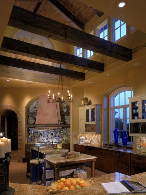 This modern Tuscan-style kitchen pays homage to the traditional details associated with the design through its use of color, architecture and accessories. Wood rafters help enclose the kitchen, while exposing the cathedral ceilings and intricate, artistic murals along the walls and ceilings. Simple wrought iron fixtures showcase Old World appeal with a contemporary edge. With massive wooden beams, terra-cotta tiles from Italy and hand-painted frescoes of Italian vineyards — this kitchen cook... Tuscan Home Decorating, Tuscan Architecture, Tuscan Design, Tuscan Kitchen, Tuscan House, Casas Coloniales, Ideas Room, Tuscan Decorating, Tuscan Style