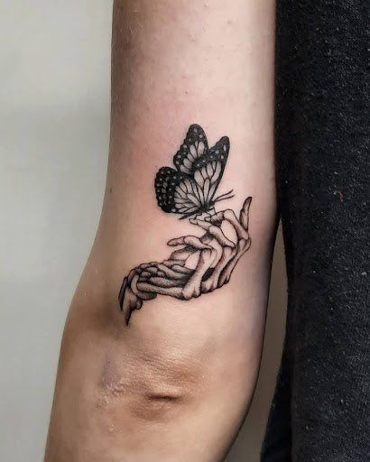 Woman In Flowers Tattoo, 2x2 Tattoo Size, Western Skull Hand Tattoo, Landed Butterfly Tattoo, Skull Hand With Butterfly Tattoo, Skeleton Hand Holding Butterfly Tattoo, Flip Off Tattoo, Women Gothic Tattoo, Skeleton Hand With Butterfly Tattoo