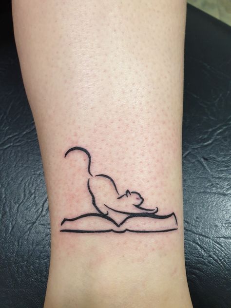 Cat and book tattoo Book And Wine Tattoo, Magic Book Tattoo, Minimal Book Tattoo Ideas, Cat Reading Tattoo, Tiny Book Tattoo Simple, Tattoo Ideas For Readers, Book Tattoo With Cat, Books And Cat Tattoo, Minimal Book Tattoo