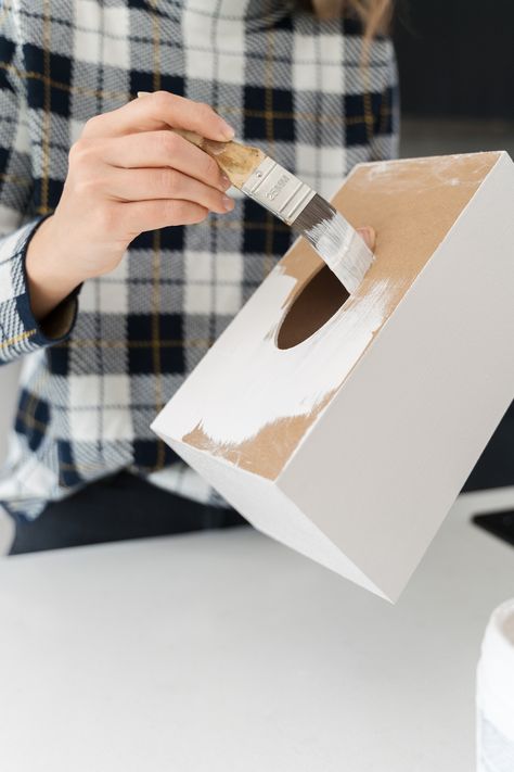 Looking for an inexpensive stylish tissue box idea? Look no further than this plain craft tissue box design using Mod Podge and tissue paper! You only need six materials to make this easy tissue box cover! Here you see Gina from Style Curator using white paint on the tissue box to create a good base. To find the full tissue box DIY, click on the pin! Wood Kleenex Box Cover, How To Make A Tissue Box Cover, How To Make Tissue Box Diy, Tissue Box Decoration Ideas, Tissue Paper Box Diy, Craft Ideas With Popsicle Sticks, Diy Kleenex Box Cover, Ideas With Popsicle Sticks, Tissue Box Covers Diy