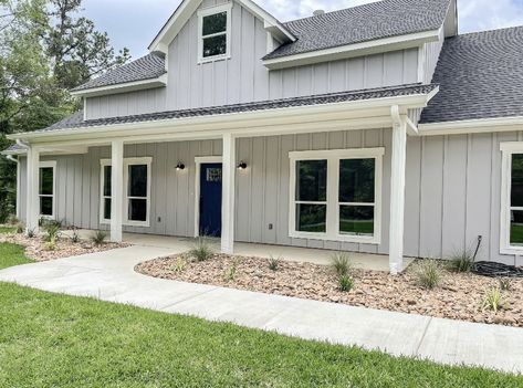 Light Grey Vertical Siding, Light Grey Modern Farmhouse Exterior, Light Grey Siding White Trim, Light Gray Ranch House Exterior, Light Grey Houses Exterior, Gray Blue Siding House, Light Grey House Black Roof, Light Gray Board And Batten Exterior, Gray Exterior House Colors Ranch Style