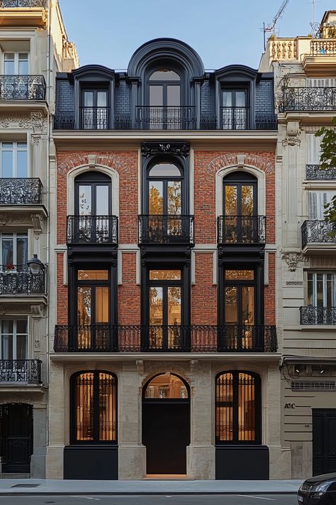 Timeless urban elegance: A classic European-style building showcases a red brick facade with intricate black wrought iron balconies. Majestic arched windows and a mansard roof adorned with dormer windows embody historical grace. These elements inspire the passive housing projects by NOVASPACE PROMOciones, where modern efficiency meets enduring beauty. Embark on your journey with us today. German Townhouse, Brick Facade Architecture Modern, Modern Brick Facade, Classical Architecture Facade, European Balcony, Red Brick Facade, Exterior Balcony, Passive House Design, Arch Building