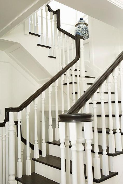 A white staircase with white spindles is contrasted with dark brown treads and a dark brown handrail. Brown Staircase, Cottage Stairs, Staircase Spindles, Stairs Makeover Design, Black And White Stairs, Stairs And Doors, White Staircase, Stair Makeover, White Stairs