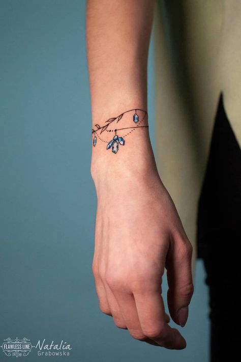 28 Wonderful Bracelet Tattoo Designs for Women Girltattoo Tattoo Ideas, Sapphire Tattoo Design, Gem Bracelet Tattoo, Sapphire Tattoo Ideas, Tattooed Bracelets, Bracelet Style Tattoo, Small Gem Tattoo, Bracelet Tattoo Women, Bracket Tattoos For Women