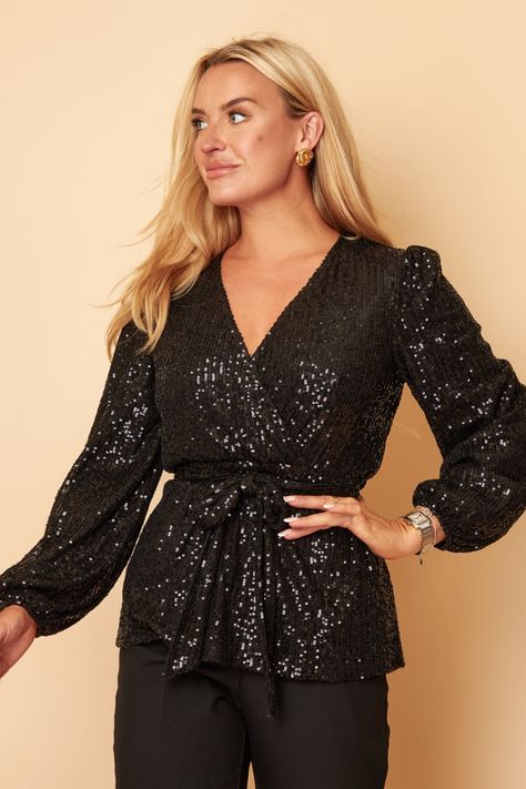 Get party ready this season with our Gabriella Black Sequin Long Sleeve Top! Featuring a wrap over neckline, balloon sleeves & gorgeous black sequin design. Pair with jeans & heels to complete the look. Model wears UK 8 and is 5'6. Measurements are based on a UK size 8 sample, there's 5 cm between each size up for bust and waist. 1 cm per size up for the length. Bust: 86 cm Waist: 64 cm.  100% Polyester. Soiree Blouses, Jeans Heels, Jeans Outfit Women, Jeans With Heels, Women Dresses Classy, Sequin Design, Fashion Design Sketches, Balloon Sleeves, Black Sequins