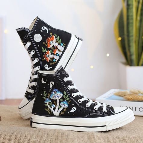 "Black Converse High Top shoes embroidered with mushroom garden and ghosts. With many years of shoe embroidery experience, this time I was really happy to receive a personalized canvas sneaker embroidery design for a very special customer. They sent me pictures of mushrooms in their favorite colors and they wanted me to combine it with ghosts. I found this request interesting and this was the gift they wanted to send to their loved ones. I also love this custom embroidery style. If you also need a pair of hand-embroidered Converse Shoes as a gift of the highest quality or a pair of hand-embroidered Vans Shoes, please message me. I will design and embroider a special pair of shoes. * The detail information of product: '' Custom Converse Chuck Taylor 1970s Embroidered Ghosts and Mushrooms Sn Converse Color Mouse, Vans High Top Sneaker Custom, Sneaker Embroidery, Embroidered Mushrooms, Shoe Embroidery, 1970s Shoes, Embroidered Vans, Cute Converse Shoes, Embroidery Styles