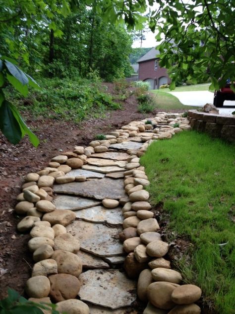 Many wanting to designed dry creek beds often end up with a drainage ditch. In terms of functions and form, they do not perform as a dry creek should perform. Truly, they help in pushing away the excess waste and dirt, but they simply lack the artistic realism of a dry creek. If you look … Creek Ideas, Dry Stream, Garden Stream, Landscape Drainage, Yard Drainage, Dry Creek Bed, Dry River, River Rock Landscaping, Creek Bed