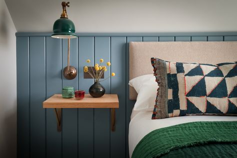 We brought character to an eaves bedroom with smoky blue panelling and a simple wall hung headboard. The oak bedside shelf makes the most of the space while providing a warm contrast. We finished the look with bold textiles and an industrial style lamp. Eaves Bedroom, Tongue And Groove Panelling, International Interior Design, London Interior Design, Villa Interior, Interior Design London, Wall Panels Bedroom, London Interior, Boutique Interior Design