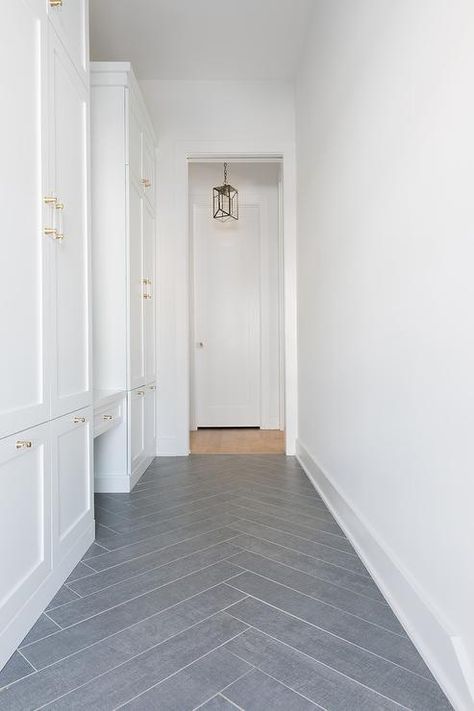 Gray slate herringbone pattern floor tiles accent white shaker mudroom cabinets stacked and fitted with brass and glass pulls. Shaker Mudroom, Herringbone Mudroom, Herringbone Brick Pattern, Black Home Exterior, Kitchen Flooring Trends, Herringbone Tile Floors, Mudroom Cabinets, Mudroom Flooring, Slate Tiles