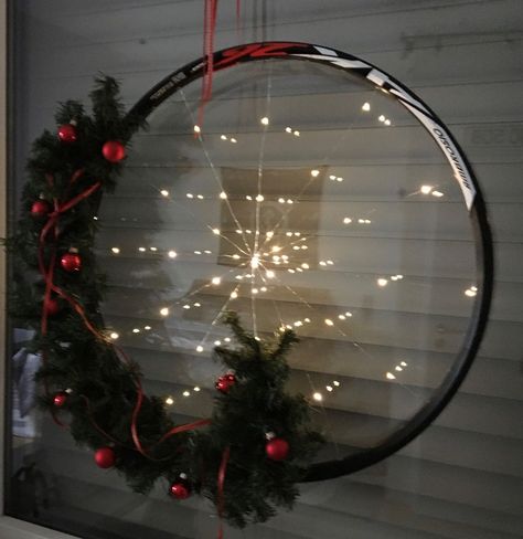 My husband and I are avid cyclist. All six of our bikes, which we ride frequently, live inside the house and are mounted on the walls as our "Ridable Art". We have many used bicycle parts and I decided to make one of our old wheel rims into a Christmas wreath.   Repurposing an old Bicycle wheel into a Christmas Wreath.   I started with a string of battery powered Fairy Lights.    And an old bicycle wheel rim. None of our old rims have spokes in them so I went for the illusion of spokes… Bicycle Wheel Decor, Bicycle Crafts, Battery Powered Fairy Lights, Bicycle Decor, Old Bicycle, Wheel Decor, Deco Mesh Christmas Wreaths, Wheel Art, Bicycle Wheel