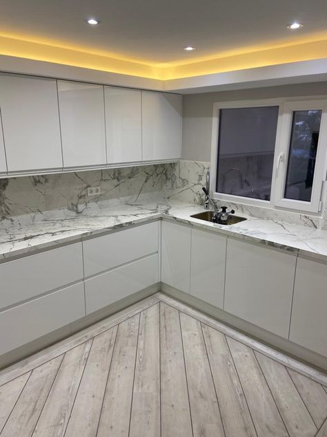 Clinical White gloss handless doors with Calcutta marble worktops using the waterfall effect | Unique Kitchens & Bedrooms Handless Kitchens, Kitchen Marble Worktop, Handless Doors, Marble Worktop, High Gloss Kitchen, Calcutta Marble, Marble Worktops, Gloss Kitchen, Marble Backsplash