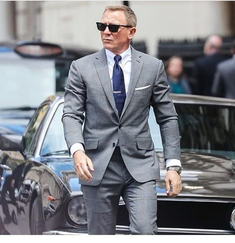 James Bond grey suit white shirt and navy blue tie Grey Suit Blue Tie, Grey Suit White Shirt, Grey Suit Combinations, Yellow Jacket Outfit, James Bond Suit, Daniel Craig Style, Mustard Yellow Outfit, Light Grey Suit, Bond Suits