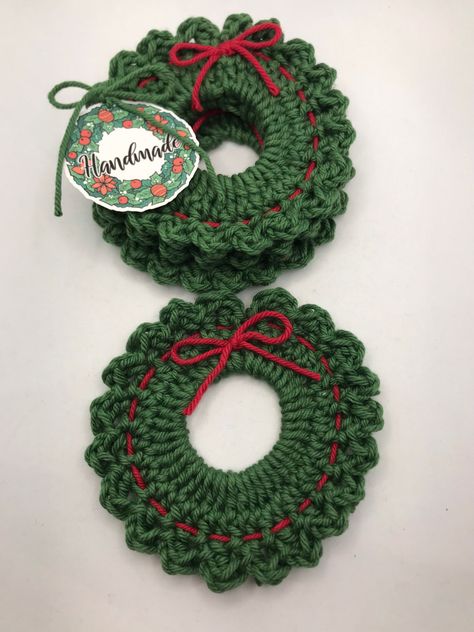 This is a set of 4 Christmas Wreath crochet coasters.   These 4 wreath coasters are decorative in color and great for home decor look for Christmas. They are crochet using cotton yarn. They are great for hot and cold beverages. These are handmade using cotton blend in a smoke and pet free home.  Hand wash coasters to not ruin the red bow. Green Coasters Crochet, Small Crochet Gifts Christmas, Crochet Christmas Tree Coaster, Christmas Crochet Decor Ideas, Crochet Gift Christmas, Christmas Crochet Headband, Crochet For Christmas Gift Ideas, Winter Crochet Decor, Simple Crochet Christmas Gifts