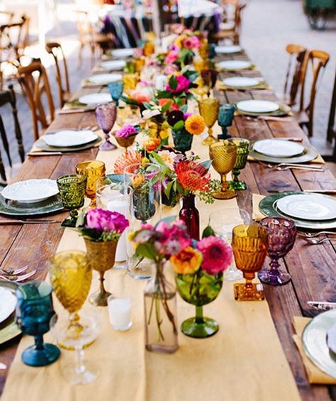 This is the detail your wedding tablescape is missing. Deco Champetre, Fiesta Wedding, Tafel Decor, Festive Wedding, Boda Mexicana, Garden Wedding Decorations, Outdoor Dinner, Colored Glassware, Ruby Wedding