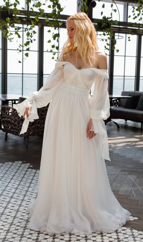 Esmee wedding dress | Boho Bohemian Collection 2021 | La Petra by Anna Sposa Group. Simple elegant wedding dress boho bohemian style. Classy white color modest wedding dress. Off the shoulder wedding dress with long sleeves. Inetersting bodice with draping. Wedding dress with belt. Modern modest wedding dress for elegant bride. Light airy wedding dress 2020. Boho wedding dress bohemian. Boho Wedding Dress With Off The Shoulder Sleeves, Off The Shoulder Poofy Sleeve Wedding Dress, Off The Shoulder Wedding Dress Flowy, Boho Minimal Wedding Dress, Billowy Sleeve Wedding Dress, Folksy Wedding Dress, Flowy Off The Shoulder Wedding Dress, Peasant Sleeve Wedding Dress, Flowy Ethereal Wedding Dress