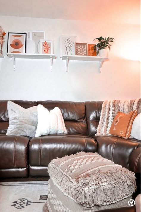 Decorating a living room with a dark brown couch can be difficult especially when you have dark brown floors. My washable rug from @ruggable. My boho fringe pouf from @smartfurniture and artwork from @desenio #boho #moroccanrug #artwork #ruggable #boholivingroom #aesthetic #decor #interiordesignideas #bohemian #bohostyle #bohodecor Brown Leather Sectional Living Room Boho, Living Room Design Dark Couch, Dark Brown Sectional Living Room Ideas, Dark Leather Couch Decor, Faux Grass Wall Living Room, Dark Leather Sectional Living Room Decor, Dark Brown Recliner Living Room Decor, Dark Leather Sectional Living Room, Dark Brown Leather Couch Living Room Ideas