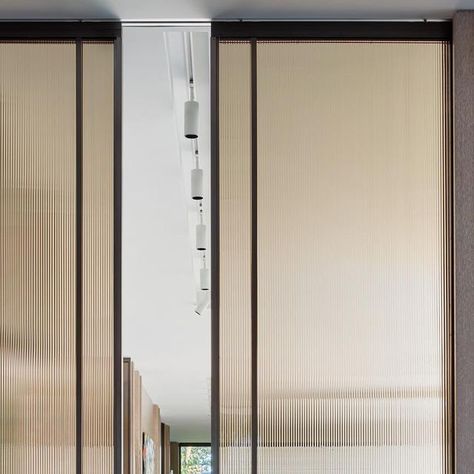 Robbins Architecture on Instagram: "Custom steel doors with bronze ribbed glass was our artful solution to add privacy without loosing light. In fact, the light seemed to dance along its face. Set within stained walnut panels, the metal, glass and wood brought a rich and soulful layer of beautiful craftsmanship throughout the home. ⠀⠀⠀⠀⠀⠀⠀⠀⠀ I only met a handful of the artists who were part of the execution, but feel like they radiate the pride and talent that went into bringing them to life. Sliding Reeded Glass Door, Bronze Glass Door, Reed Glass Door, Ribbed Glass Wardrobe, Rippled Glass Door, Reed Glass Sliding Door, Steel Doors, Glass Door, Stained Glass