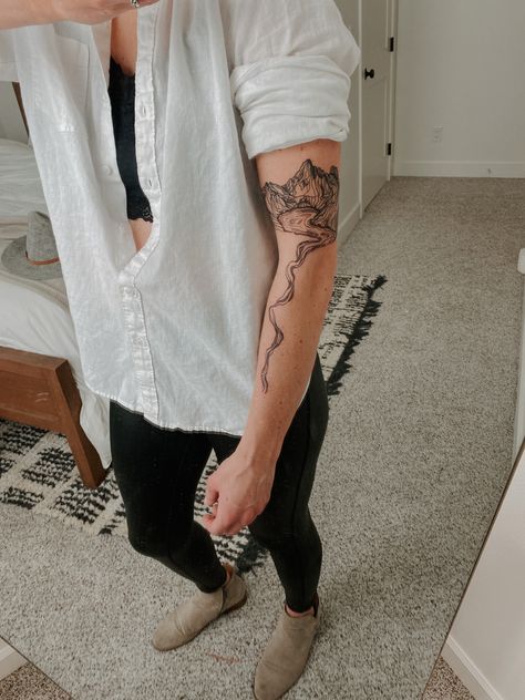 Woman’s minimal geometric mountain and lake tattoo in black ink. Back Tattoo Women Mountain, Water Tattoo Sleeve Women, River Inspired Tattoos, Cascading Tattoos, River Arm Tattoo, Waterfall Tattoo Minimalist, Upper Calf Tattoo Women, Cascade Mountains Tattoo, River Topography Tattoo