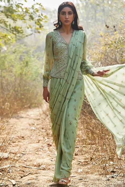 Featuring a mint pre-stitched saree in georgette base with sequins, zari, dabka, cutdana, and moti hand embroidery including lily print. It is paired with a matching jacket and a blouse having balloon sleeves. This contains only three pieces.     FIT: Fitted at bust and waist.  COMPOSITION: Georgette.  CARE: Dry clean only. Luxury Chanderi Pre-draped Saree For Designer Wear, Luxury Anarkali Pre-draped Saree In Pista Green, Luxury Pre-draped Saree With Zari Work In Art Silk, Luxury Raw Silk Pre-draped Saree With Mirror Work, Luxury Chanderi Pre-draped Saree For Transitional Season, Luxury Art Silk Pre-draped Saree With Zari Work, Luxury Bollywood Style Pre-draped Handloom Saree, Luxury Pre-draped Saree With Printed Motifs, Cheap Bollywood Style Pre-draped Saree With Zari Work