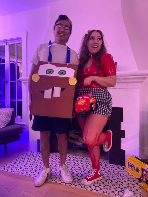 Couples costume, Man wearing a cardboard box painted to look like Mater from the Cars Movie. Women next to him wearing red latex top, black & white checkered skirt, red flame fishnet tights, red high top converse, and holding a lightning McQueen purse. Lightning Mcqueen Costume Couple, Lightning Mcqueen And Mater Costume Couple, Cars Costume Couple, Incredibles Couple Costume, Cars Halloween Costume Couple, Cars Couple Costume, Lightning Mcqueen Halloween Costume, Lightning Mcqueen Costume Women, Lightning Mcqueen And Mater Costume