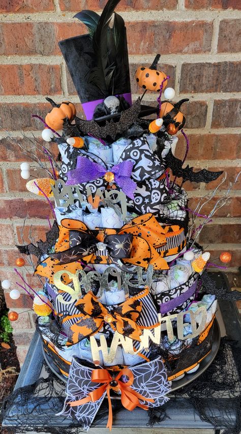 This is a spunky interpretation of a diaper cake with Halloween twist. Halloween Diaper Cake Ideas, Little Boo Baby Shower Ideas Cake, Nightmare Before Christmas Diaper Cake, Spooky Diaper Cake, Diaper Cake Halloween Theme, I Smell A Child Baby Shower Theme, Halloween Themed Diaper Cake, Boo-y Or Ghoul Gender Reveal Cake, Halloween Diaper Cake