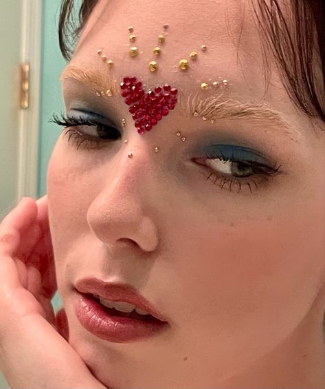 Heart Inspired Makeup, Heart Glitter Makeup, Sacred Heart Makeup, Gemstones On Face, Pearl Face Gems, Heart Makeup Ideas, Jewel Makeup Looks, Heart Eye Makeup Look, Gold And Red Makeup