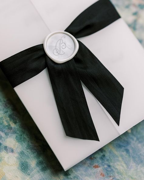 What’s a vellum gatefold? Oh let me tell you! Vellum is this beautiful frosted/translucent paper that we fold around the invitation. Seen her with our black silk ribbon and 1.25” pearl wax seal. Such an awesome addition to any of our wedding invitation suites! Photography: @sarahblazephotog #velluminvitation #velluminvitations #velluminvites #vellum #vellumgatefold #weddingvellum #weddinginvitations #moderninvitations #blackandwhitewedding #weddinginspo Vellum And Ribbon Invitations, Vellum Wrapped Wedding Invitations With Ribbon, Invitation With Ribbon And Wax Seal, Wedding Invitation Vellum Wrap, Black Ribbon Wedding Invitations, Pearl Wedding Invitations, Pearl Wax, Fine Stationery, Black Wedding Invitations