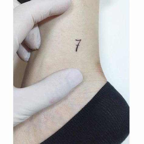 Minimalistic number "7" tattoo located on the ankle. Tattoo 7 Number Design, Tiny 7 Tattoo, Ankle Number Tattoo, 7 Number Tattoo, Number 7 Tattoo Design, Number Seven Tattoo, 7 Tattoo Number Design, Number 7 Tattoo, Minimalist Lettering